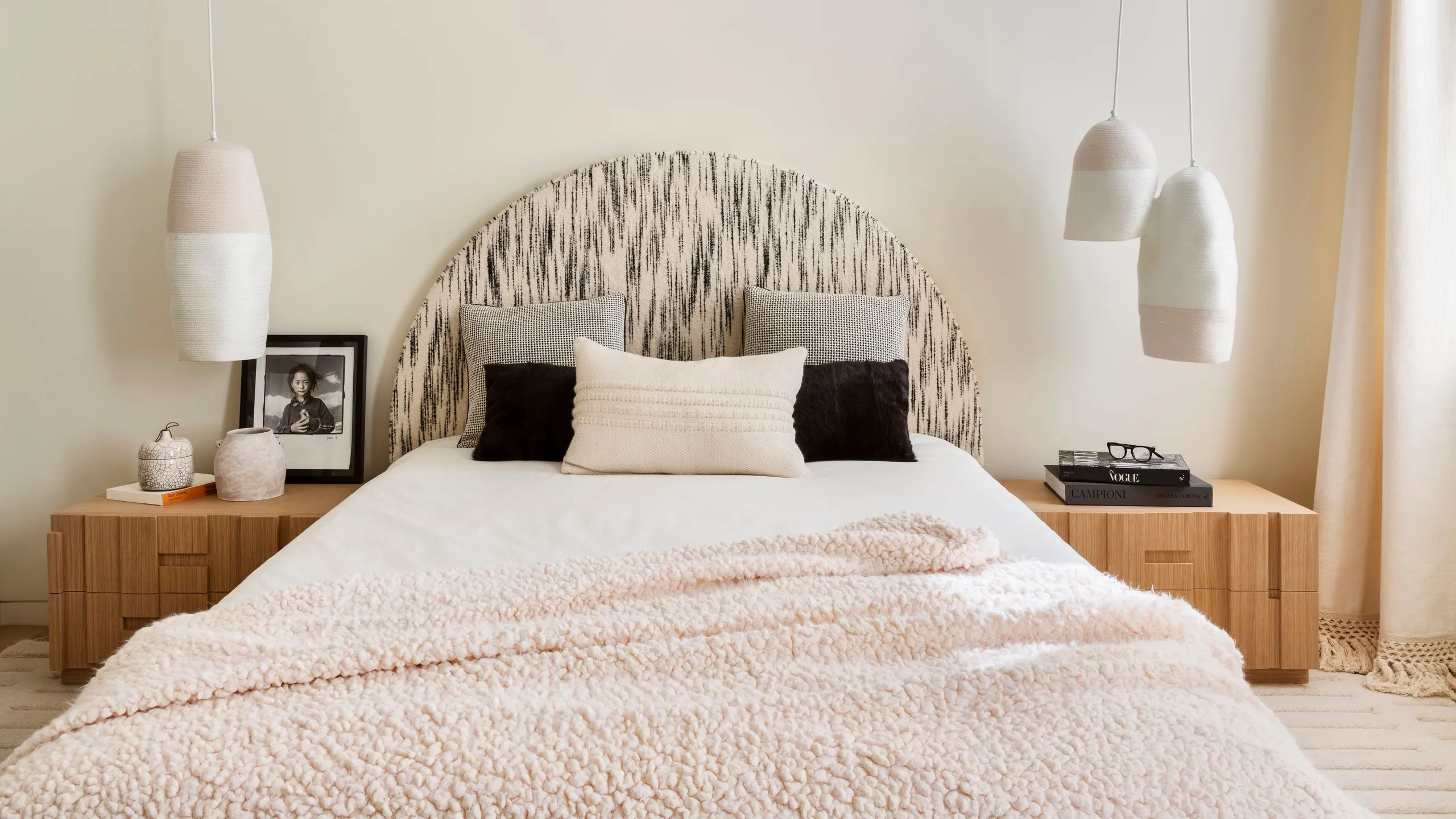 Minimalist bedroom in a Hebbal Bengaluru high-rise apartment with a low upholstered bed, linen bedding and a full-height city-facing window