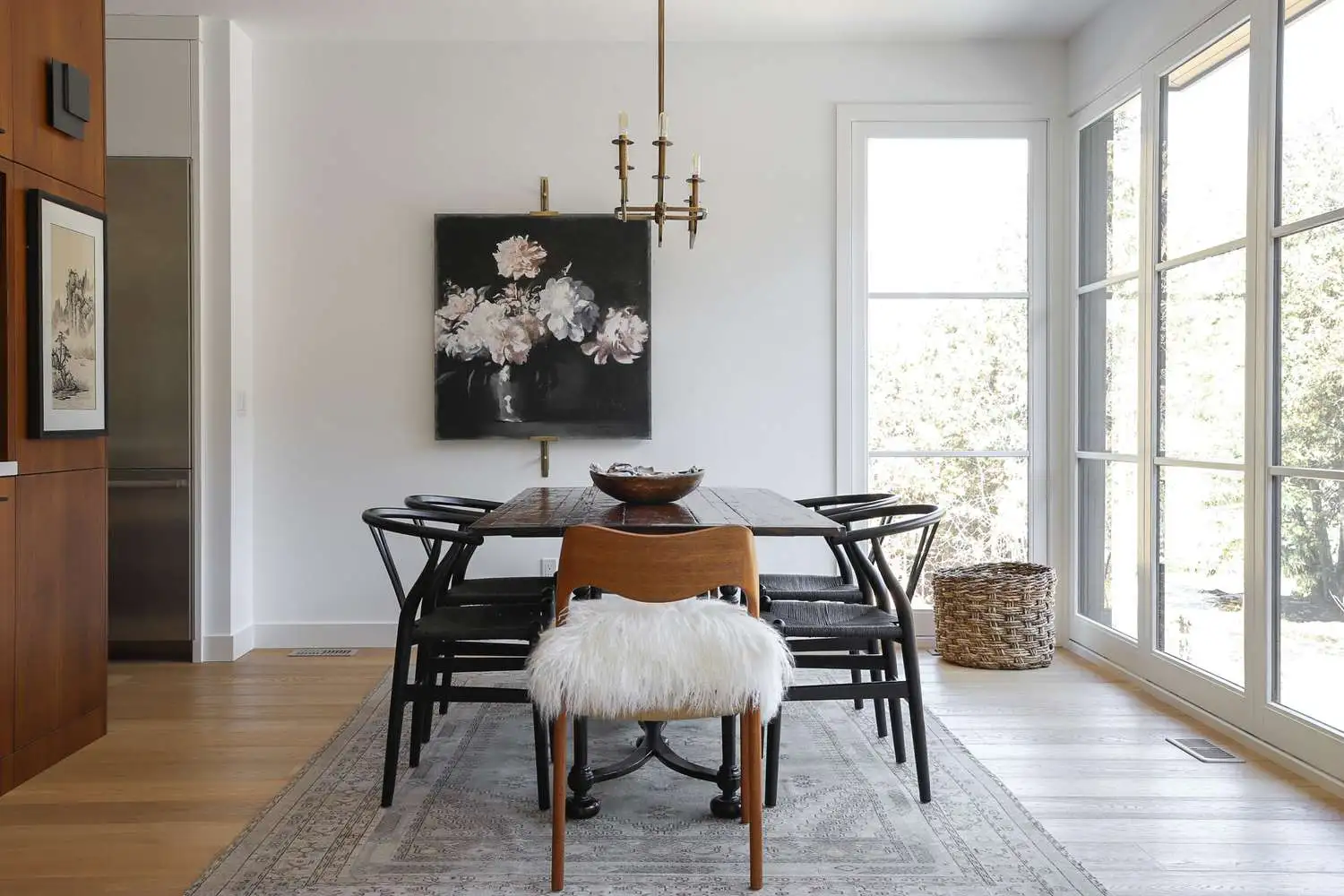 Dining room of an Indiranagar Bengaluru duplex apartment with a solid walnut table, sculptural pendant lighting and warm lime-plaster walls