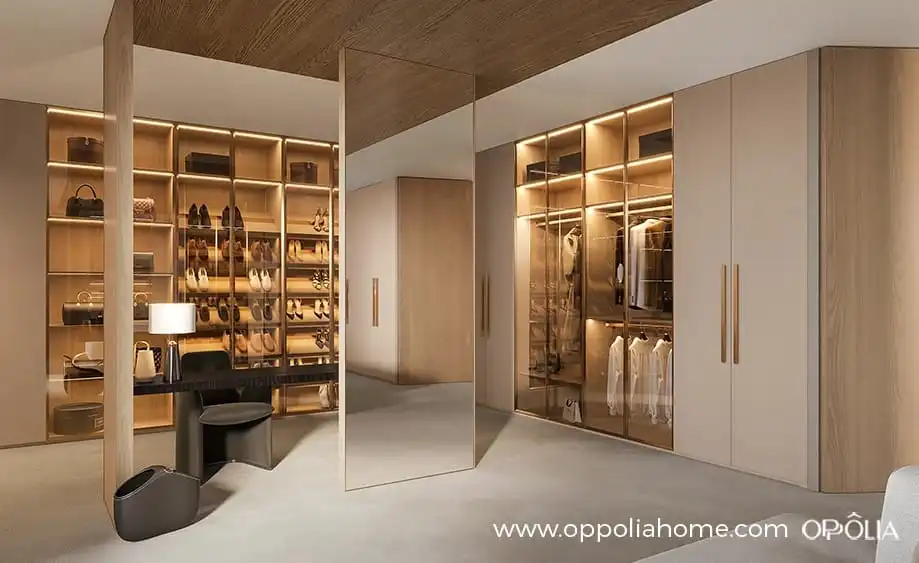 Walk-in wardrobe in a Sarjapur Road Bengaluru villa with light oak veneer cabinetry, glass-fronted display bays and integrated LED lighting